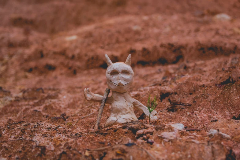 a small bunny holding a carrot standing on top of a field