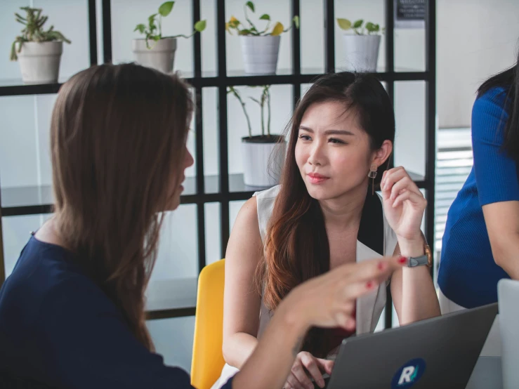 two women sitting at a table talking to each other