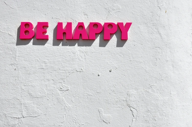 the word be happy is painted on a wall