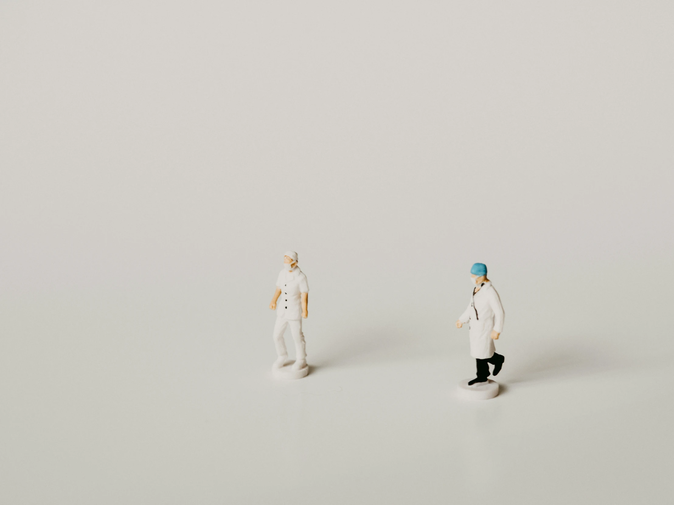 a pair of figurines standing in the middle of a white room