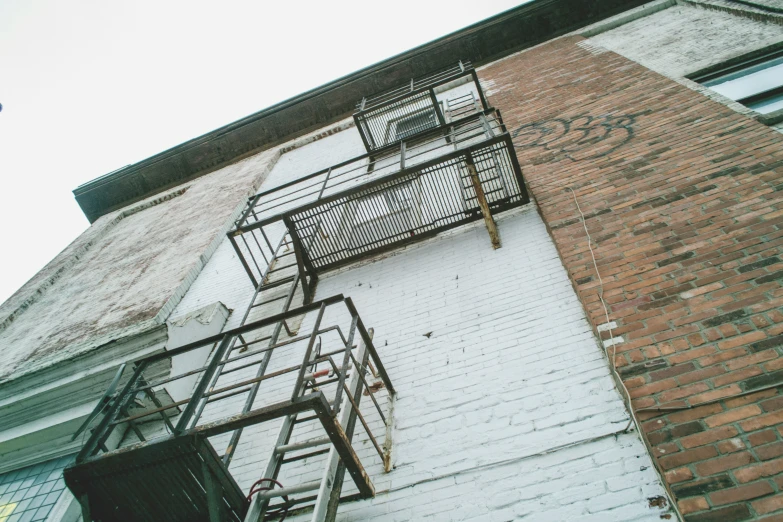 an industrial fire escape that is next to a brick building