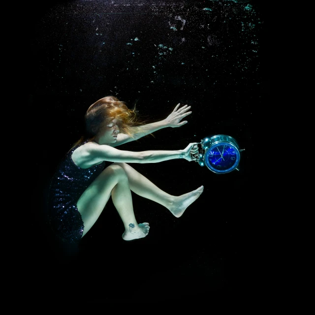 a girl is diving with a jelly ball under water