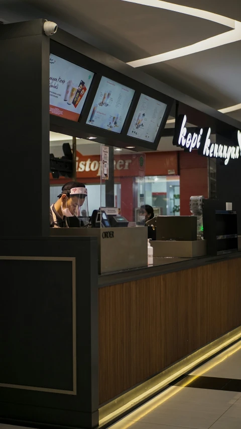 a small restaurant with two people working at the counters