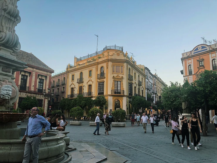 a street with a group of people walking by and a tall building