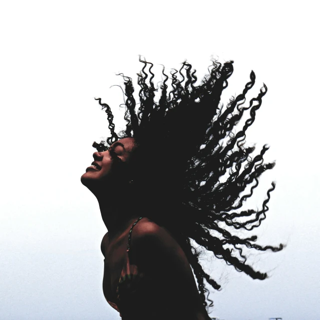 a woman with dreadlocks looking up in the air