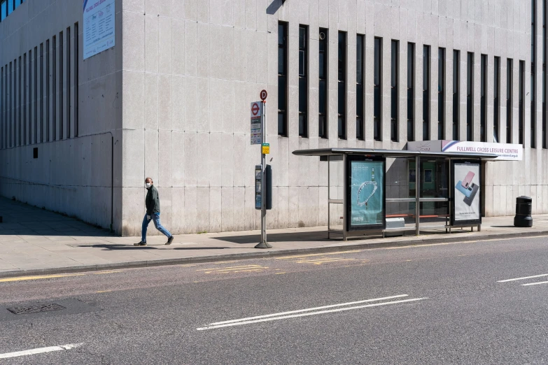 an empty street is seen, with a person walking down the sidewalk