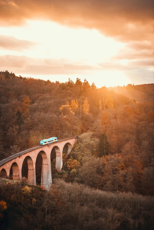 the train has stopped on the bridge on the hill