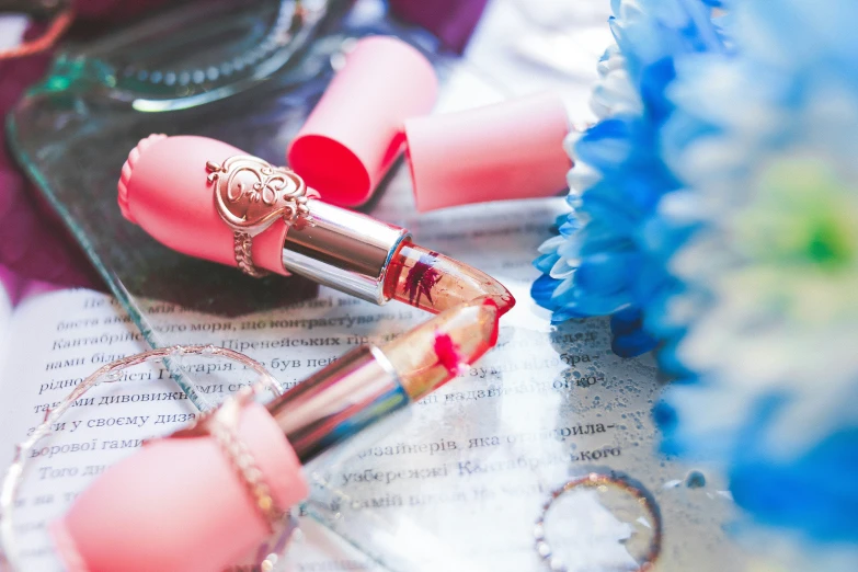 closeup of a lipstick with a gold handle and a red lipstick