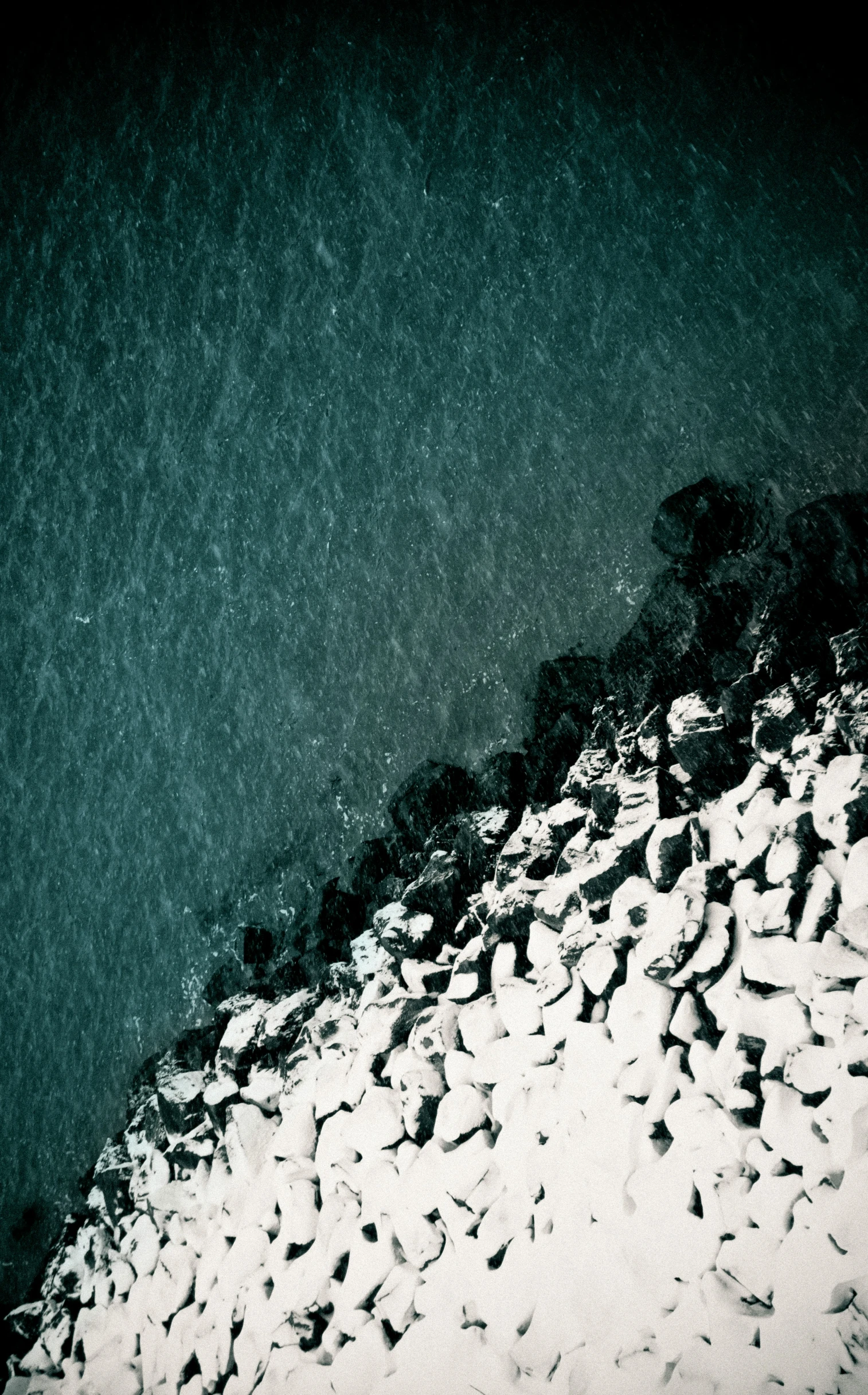 aerial pograph of rocky terrain and water at night