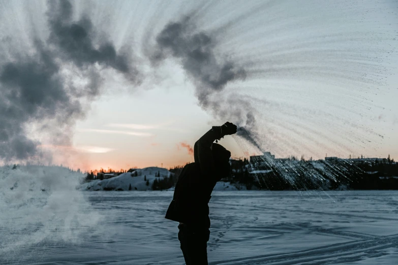 a person that is snow boarding through some smoke