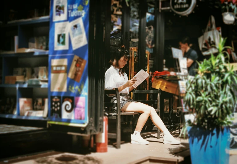 a woman sitting on a chair reading a newspaper