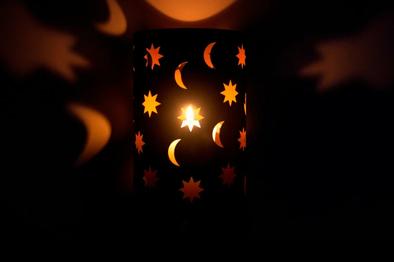 a lit candle is shown with several stars on it