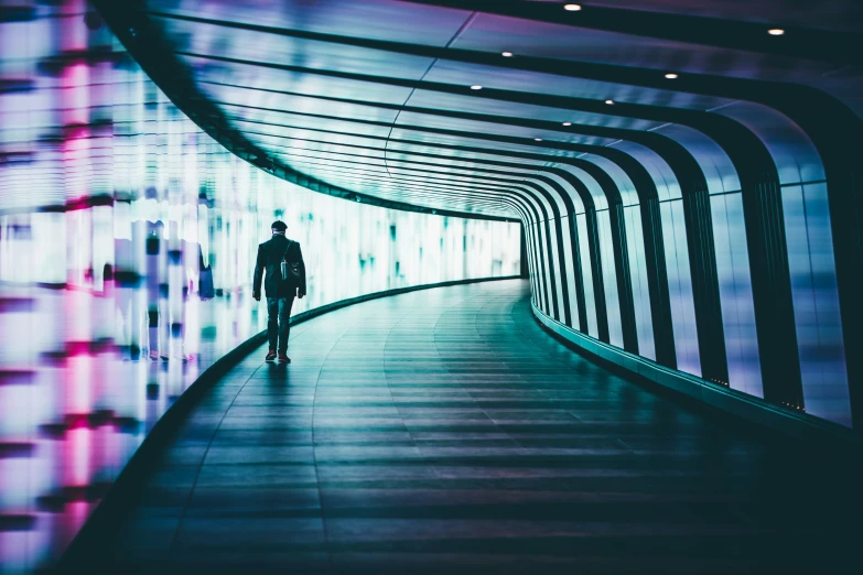 a person walking down a long walkway between two walls