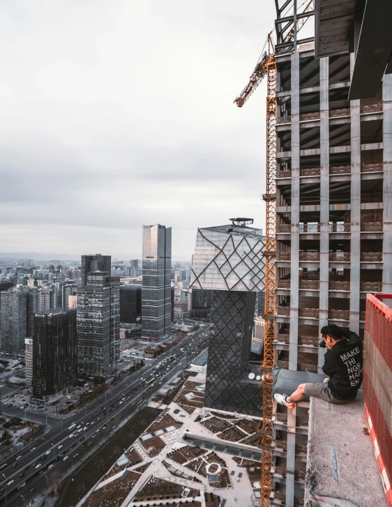 a construction worker is sitting on a ledge