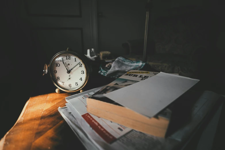 a clock sits on top of a pile of mail