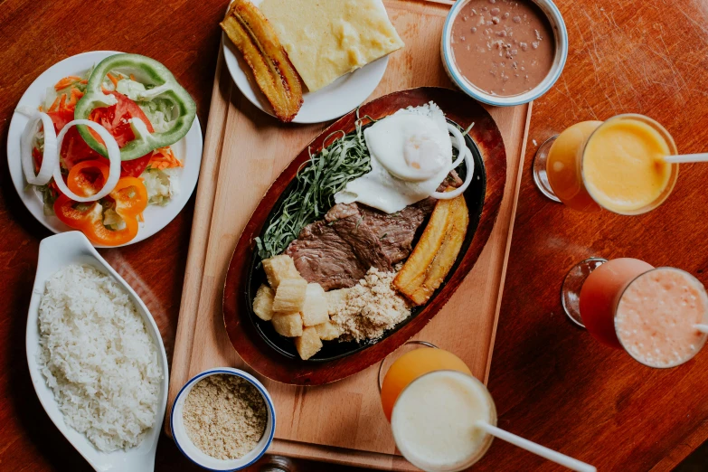 a wooden table with plates of food and drinks