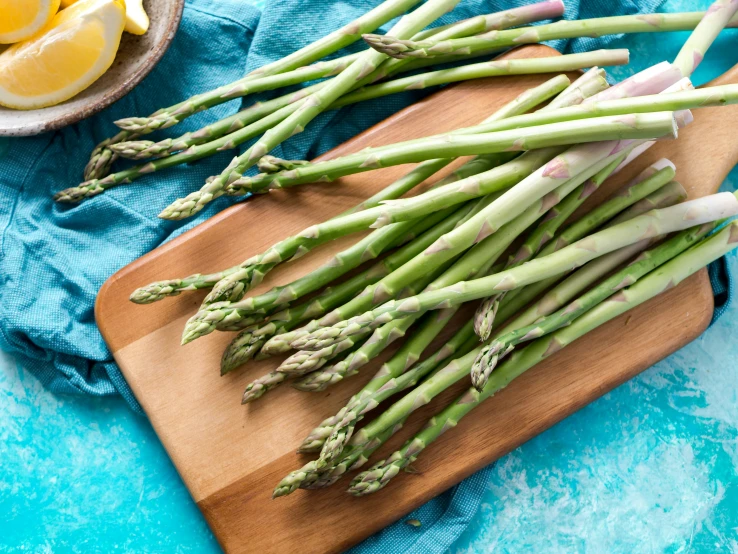 green asparagus are sitting on a  board