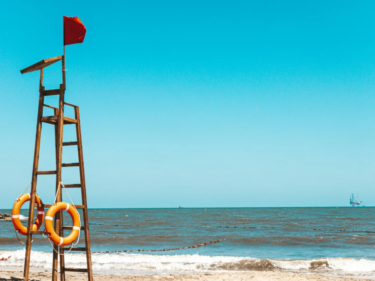 an lifeguard tower stands at the edge of the water