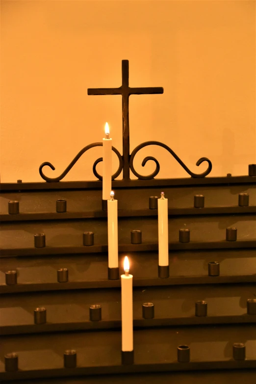 two candles with a cross atop each