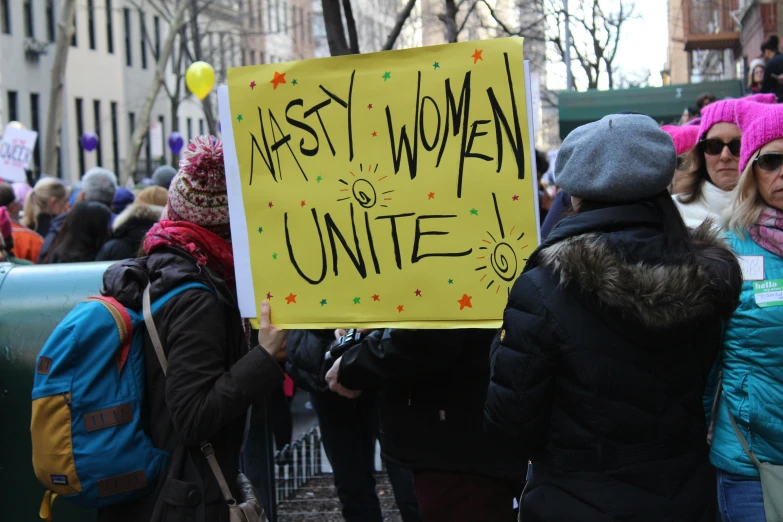 people marching in an nyc march with signs