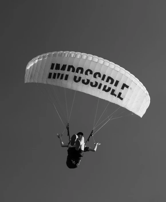 a man is para sailing in the sky holding on to a sign