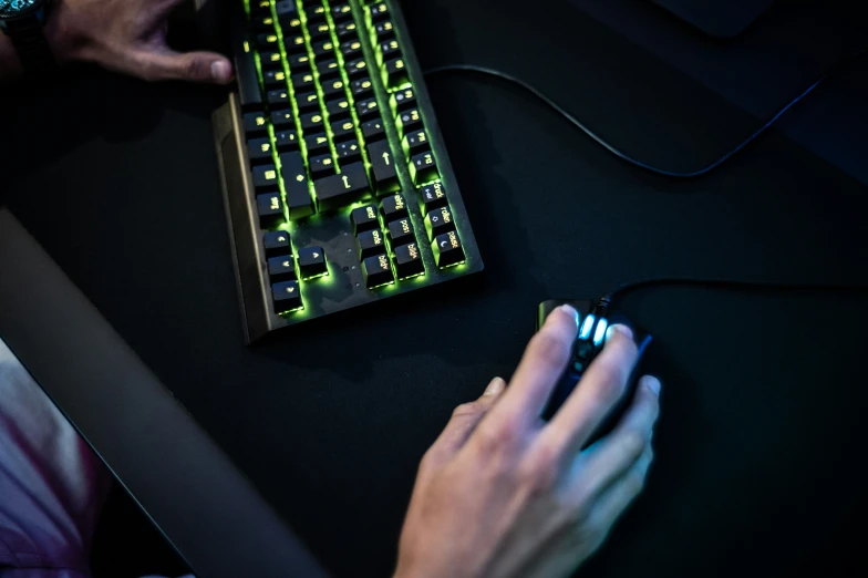 a man using a mouse, keyboard, and a laptop