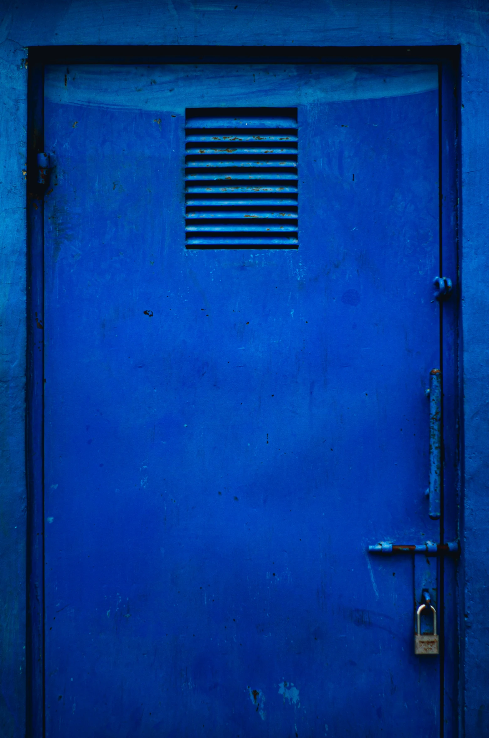 an empty, blue door with a metal handle