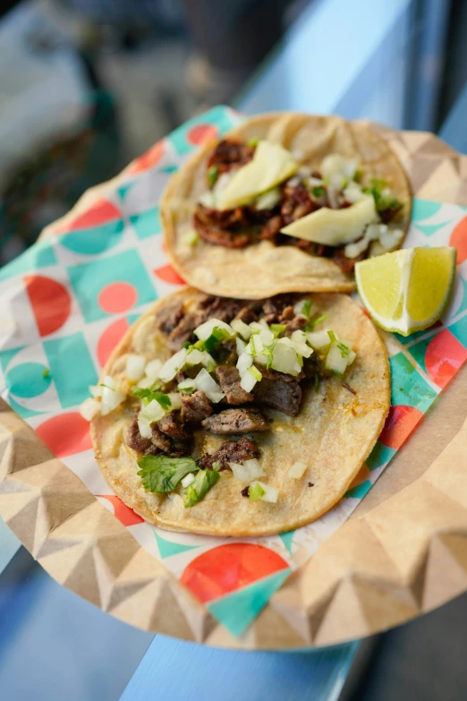 a plate with three tacos on it and a lime