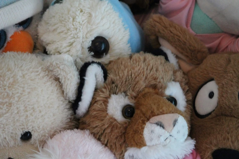 a pile of stuffed animals with eyes wide open