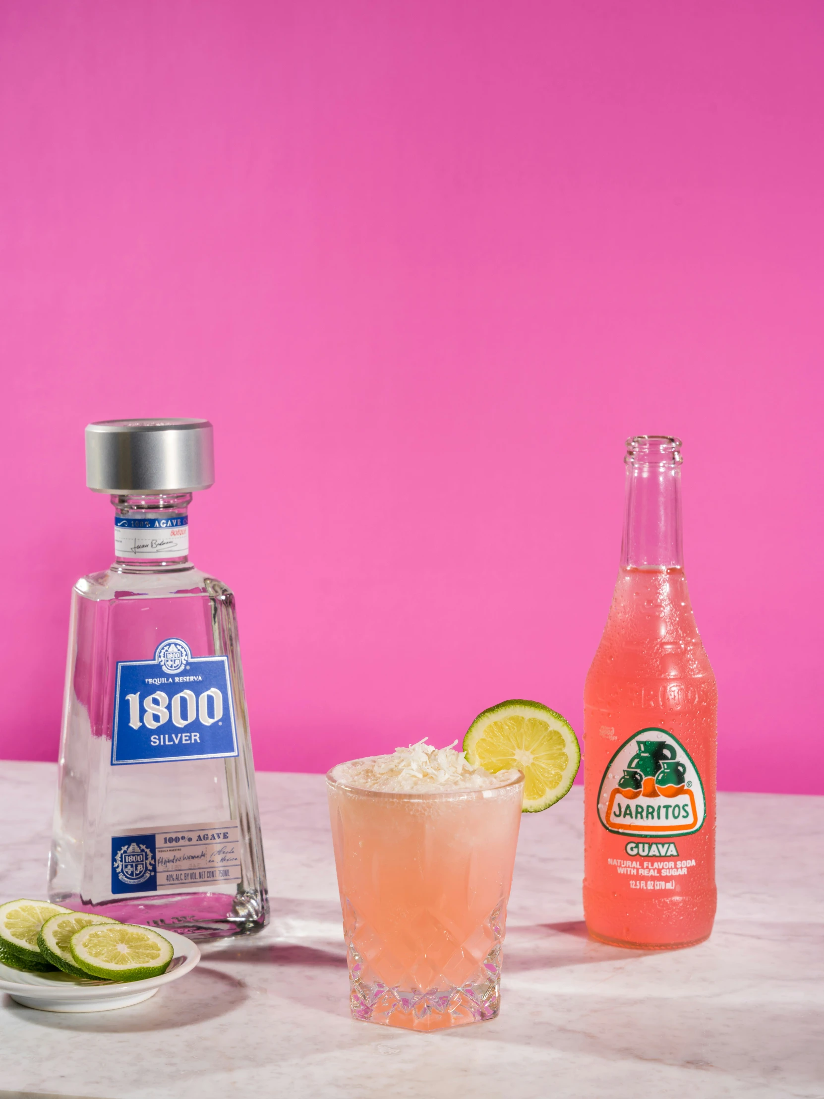 a glass and some bottles with drinks sitting on a table