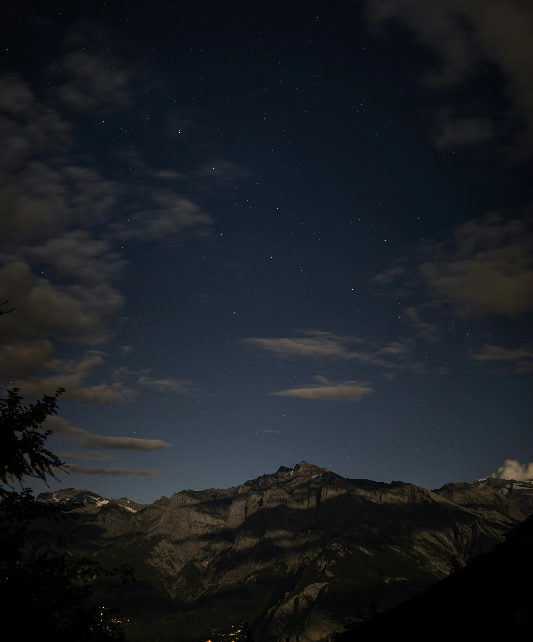 night sky with stars and clouds over the mountains