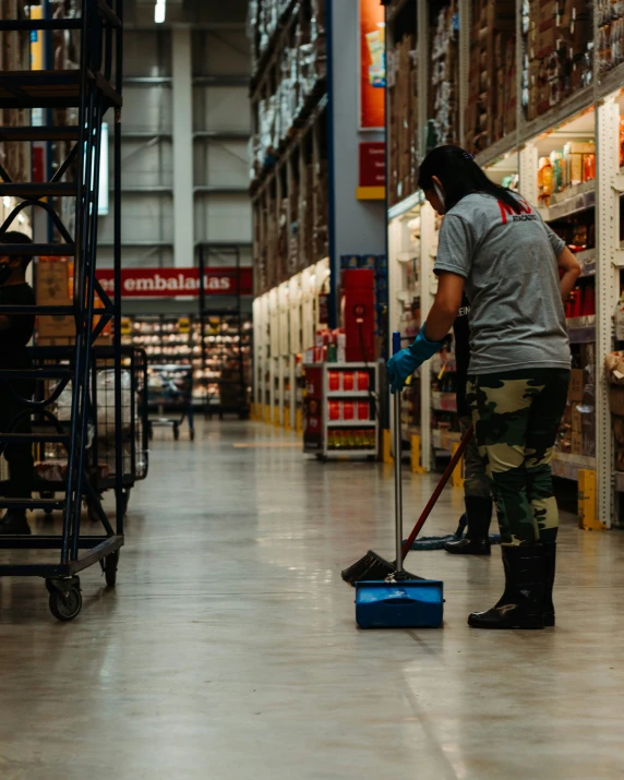 a woman cleaning the floor in a store