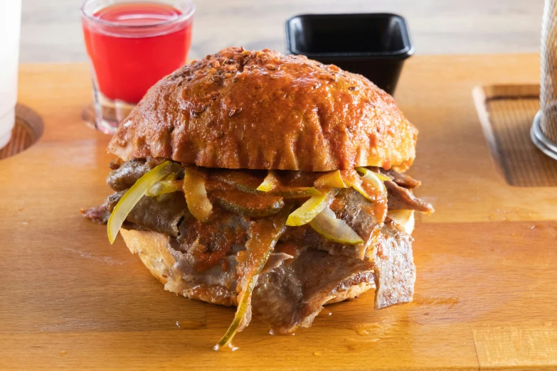 a large steak sandwich sitting on top of a wooden table