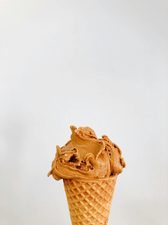 a scoop of ice cream in a waffle cone on top of a table