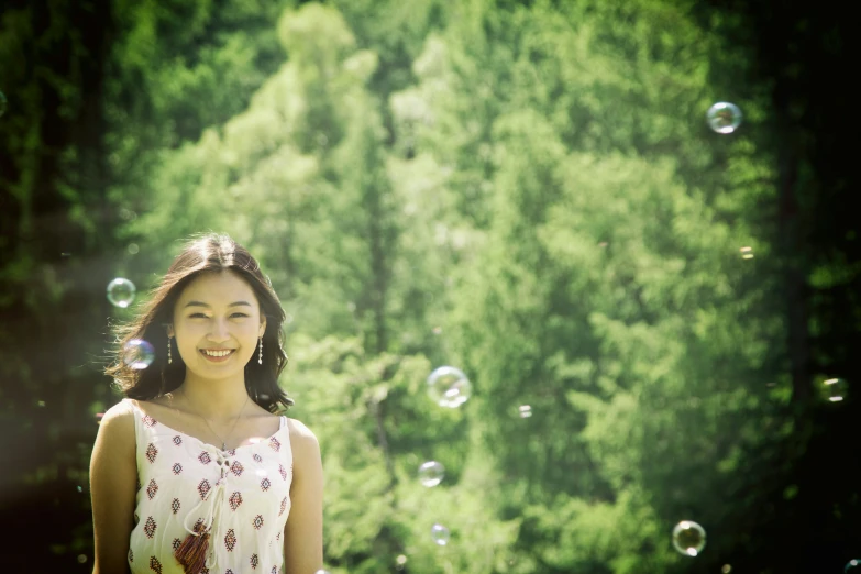 a woman standing in front of a tree covered forest