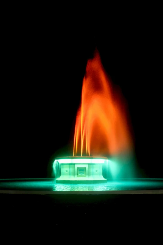 a green and red fountain in the dark