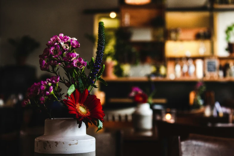 a white vase with flowers in it sitting on the counter