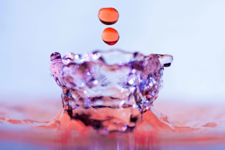 an orange bubble floating into water next to a pink diamond