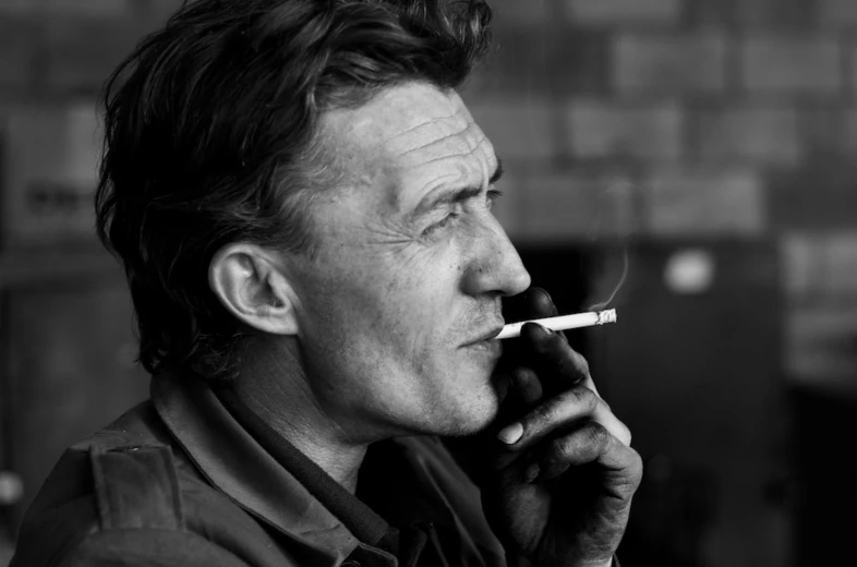 black and white pograph of man smoking cigarette