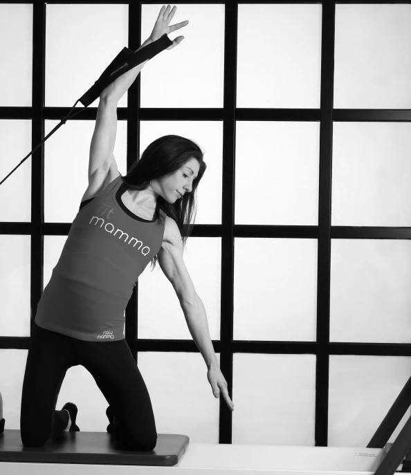 woman stretching in yoga position on mat, black and white