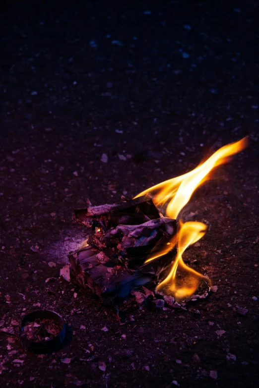 a lit fire with a purple background and some yellow flames in the center