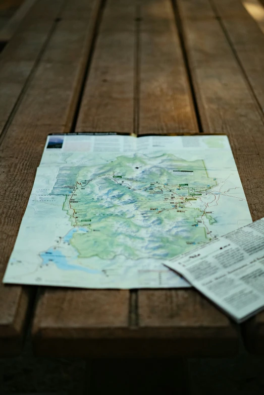 a map laying on top of a wooden bench