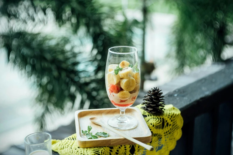 a tray holding a glass and fruits on top of it