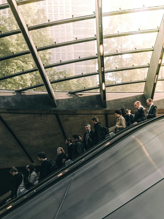 there is many people standing on an escalator in this building