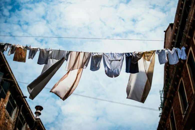 a long line of clothes hanging on an electrical line near buildings