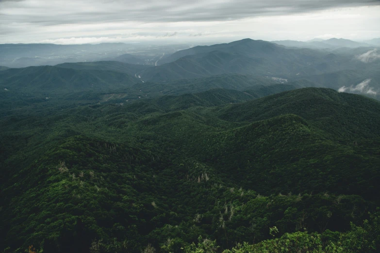 the view from the top of a mountain shows lush, green hills