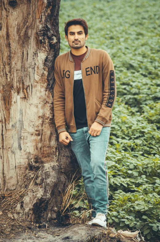 a man standing by a tree posing for the camera