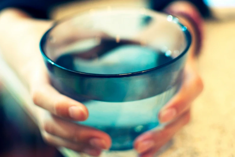 a person holding a glass filled with water