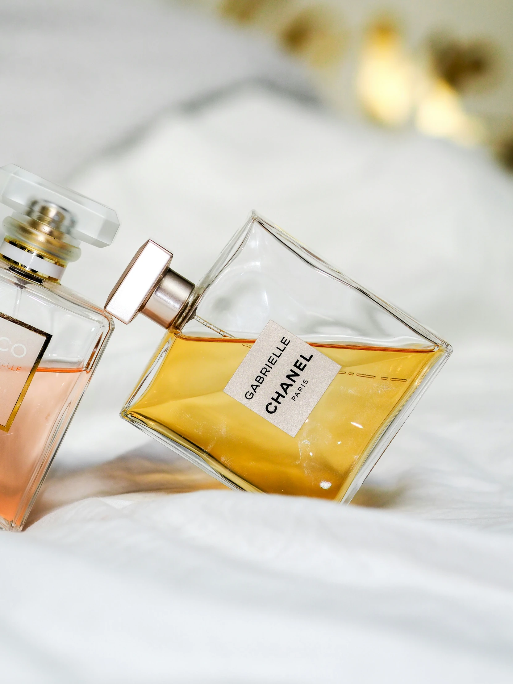 a person holding a perfume bottle near a bed