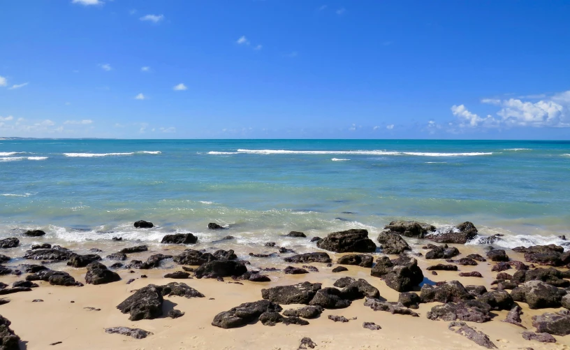 a man walking along the shore of an ocean